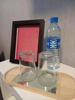 a tray with two glasses and a bottle of water at Quiet apartment near park SELF CHECK IN in Šiauliai