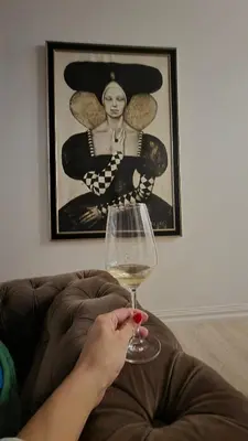 a person holding a glass of wine on a couch at City center in Kaunas