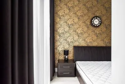 a bedroom with a bed and a clock on a wall at City center in Kaunas