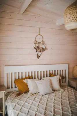 a bedroom with a large bed with a wooden wall at Miško kraštas in Vileikiai