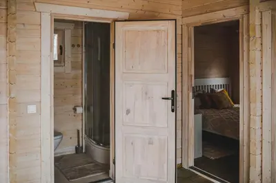 a door leading into a bedroom with a bed at Miško kraštas in Vileikiai