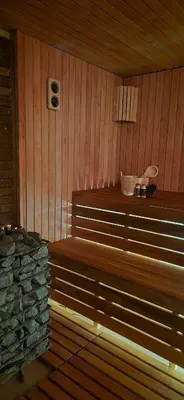 a sauna with a bench and a stone wall at Sodyba Azagis in Vilkanastrai
