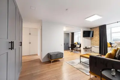 a living room with a couch and a table at Newly Refurbished Lukiskiu Square Apartment by Reside Baltic in Vilnius