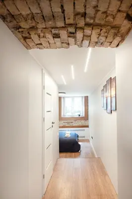 a bedroom with a bed and a wooden floor at Newly Refurbished Lukiskiu Square Apartment by Reside Baltic in Vilnius