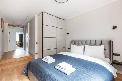 a bedroom with a blue bed with towels on it at Newly Refurbished Lukiskiu Square Apartment by Reside Baltic in Vilnius