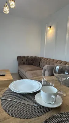 a living room with a table with two plates and a cup at Central Boulevard Apartment 2 in Šiauliai