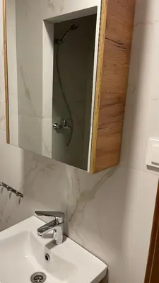 a bathroom with a sink and a mirror at Central Boulevard Apartment 2 in Šiauliai