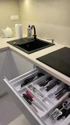 a kitchen with a sink and a drawer with knives at Central Boulevard Apartment 2 in Šiauliai