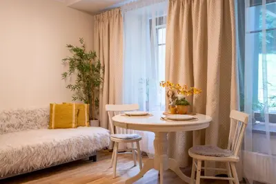 a room with a table and chairs and a window at Cozy Suite Roomita in Vilnius