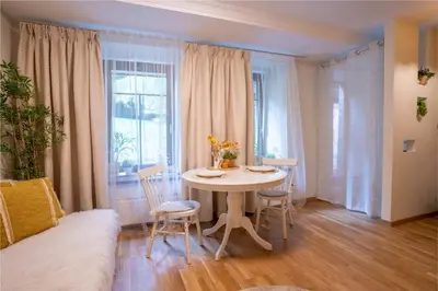 a room with a table and chairs and a bed at Cozy Suite Roomita in Vilnius