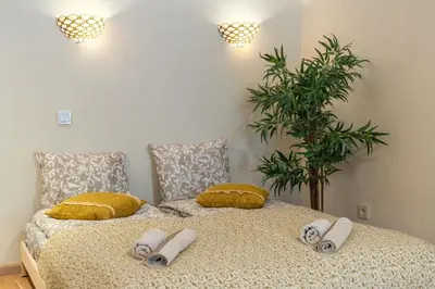 a bedroom with a bed with pillows and a plant at Cozy Suite Roomita in Vilnius