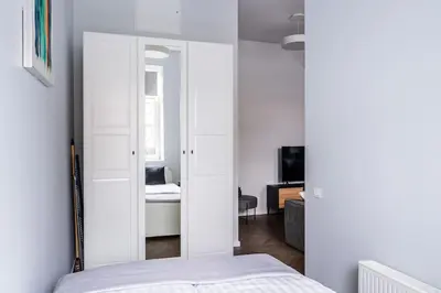 a bedroom with a mirror and a bed in a room at Modern flat in Old Town Kaunas - Parking & Self Check-In in Kaunas