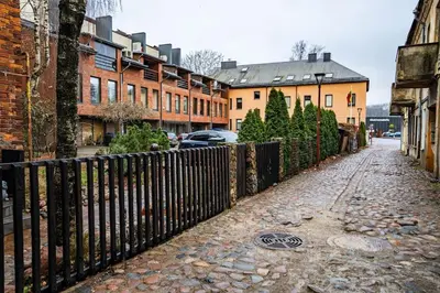 a fence on the side of a street with buildings at Modern flat in Old Town Kaunas - Parking & Self Check-In in Kaunas