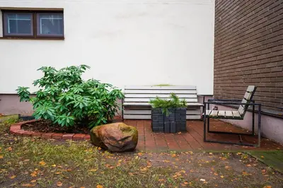 a bench sitting on a brick patio with a rock at Modern flat in Old Town Kaunas - Parking & Self Check-In in Kaunas