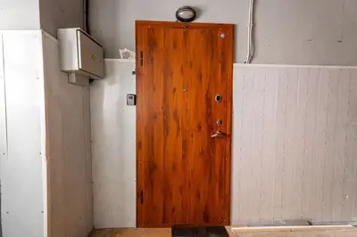 a wooden door in the corner of a room at Modern flat in Old Town Kaunas - Parking & Self Check-In in Kaunas