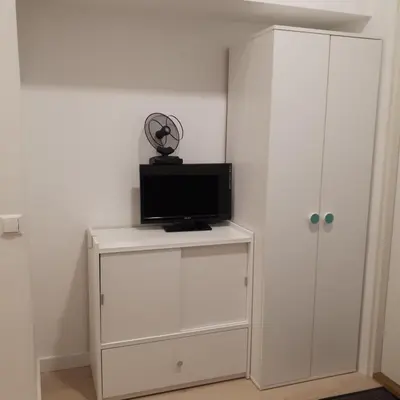 a white cabinet with a television on top of it at Mini apart Žvėrynas in Vilnius