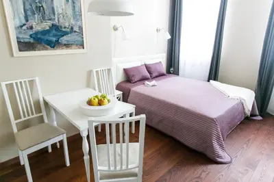 a small room with a bed and a table with a bowl of fruit at G-45 in Vilnius