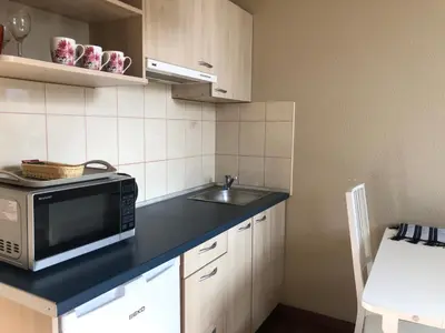 a small kitchen with a microwave and a sink at G-45 in Vilnius