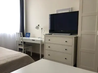 a bedroom with a dresser with a tv and a desk at G-45 in Vilnius