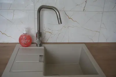 a kitchen sink with a bottle of detergent next to it at Studio Anna in Panevėžys
