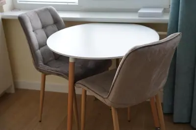 two chairs sitting next to a white table and a table at Studio Anna in Panevėžys