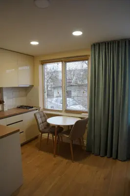 a kitchen with a table and chairs and a window at Studio Anna in Panevėžys