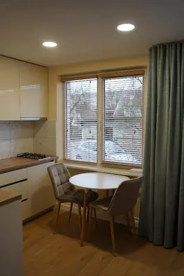 a kitchen with a table and two chairs and a window at Studio Anna in Panevėžys