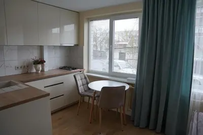 a kitchen with a table and chairs and a window at Studio Anna in Panevėžys