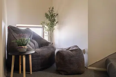 a living room with a chair and a table at Butas-loftas mieste, Kaunas in Kaunas