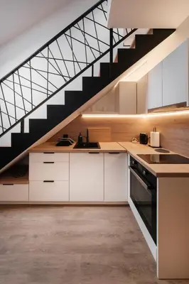 a kitchen with white cabinets and a staircase at Butas-loftas mieste, Kaunas in Kaunas