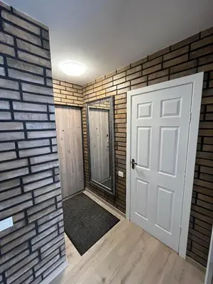 a room with a door and a brick wall at Naujai įrengtas butas trumpalaikei nuomai in Šiauliai
