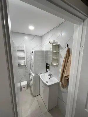a white bathroom with a sink and a toilet at Naujai įrengtas butas trumpalaikei nuomai in Šiauliai