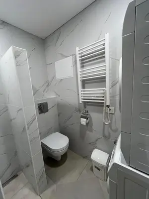 a white bathroom with a toilet and a sink at Naujai įrengtas butas trumpalaikei nuomai in Šiauliai
