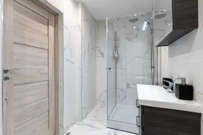 a bathroom with a shower and a sink and a toilet at Stylish Apartment For up to 4 Guests With WiFi, Free Parking in Vilkaviškis