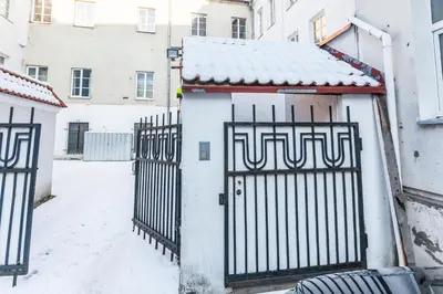 a building with a gate in the snow at Central apartments 2 x Free Parking x SELF CHECK-IN 24h by H&H in Vilnius