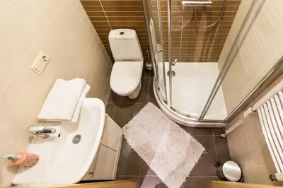 a small bathroom with a toilet and a sink at Central apartments 2 x Free Parking x SELF CHECK-IN 24h by H&H in Vilnius
