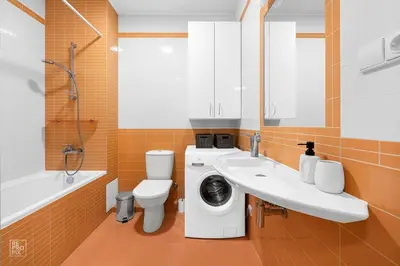 a bathroom with a toilet and a sink and a washing machine at Apartment with cozy balcony by URBAN RENT in Kaunas