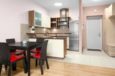 a kitchen with a table and chairs and a refrigerator at Apartment with cozy balcony by URBAN RENT in Kaunas