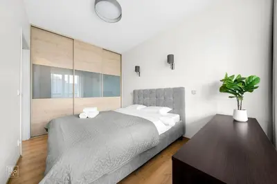 a bedroom with a large bed and a table at Apartment with cozy balcony by URBAN RENT in Kaunas