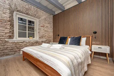 a bedroom with a large bed and a brick wall at Historic Bliss In Vilnius Old Town in Vilnius
