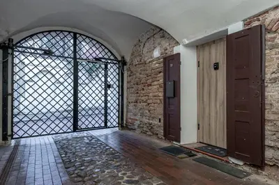 an empty room with a door and a brick wall at Historic Bliss In Vilnius Old Town in Vilnius