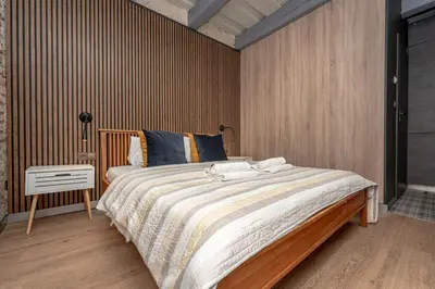 a bedroom with a large bed with a wooden headboard at Historic Bliss In Vilnius Old Town in Vilnius