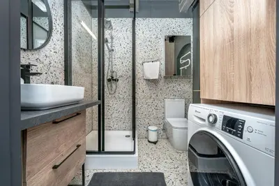 a bathroom with a sink and a washing machine at Historic Bliss In Vilnius Old Town in Vilnius
