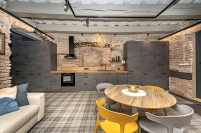 a living room with a wooden table and yellow chairs at Historic Bliss In Vilnius Old Town in Vilnius
