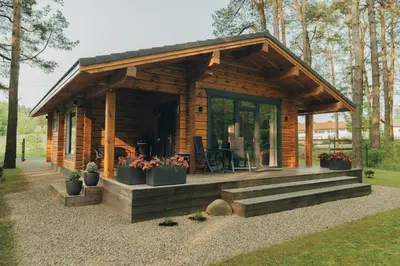 a log cabin with a porch and some plants at 
