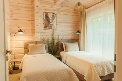 two beds in a room with wooden walls at 