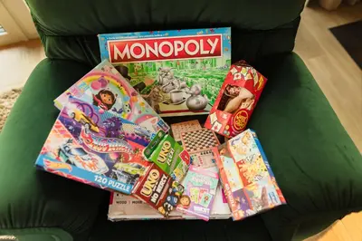 a pile of toys and games on a green couch at 