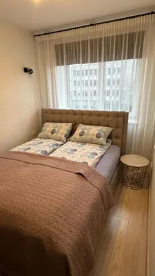 a bed in a room with a window and a bed sidx sidx sidx at Central Boulevard Apartment 2 in Šiauliai