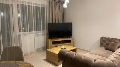 a living room with a couch and a flat screen tv at Central Boulevard Apartment 2 in Šiauliai