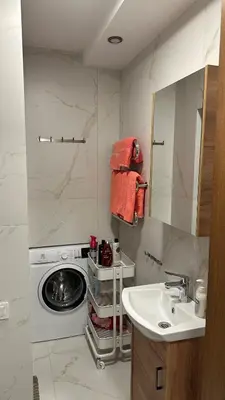 a bathroom with a sink and a washing machine at Central Boulevard Apartment 2 in Šiauliai